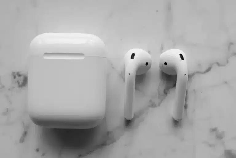 White wireless earbuds on a minimalist tech surface symbolizing Apple's latest audio innovation