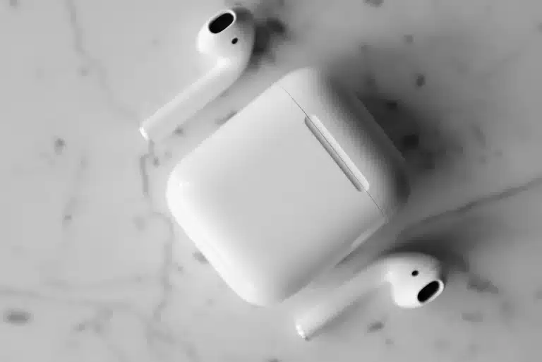 Premium wireless earbuds with charging case on a clean desk surface