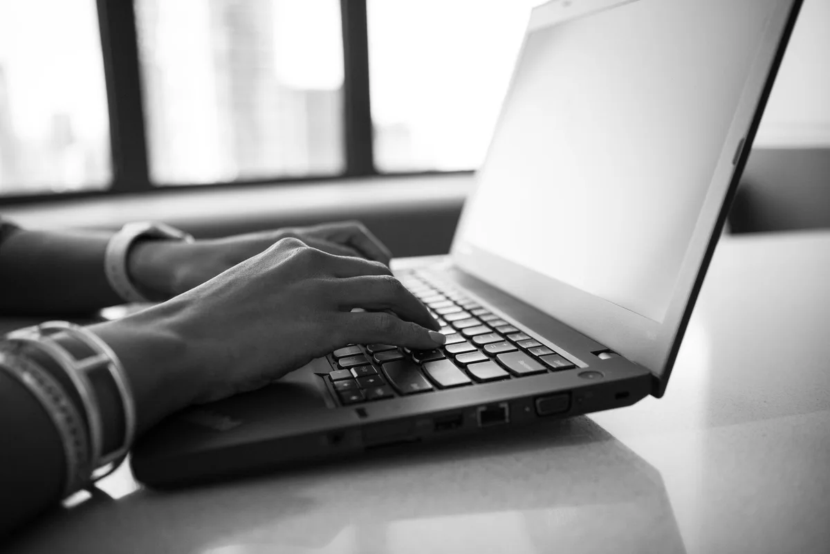 Person typing on a laptop keyboard for extensive writing tasks