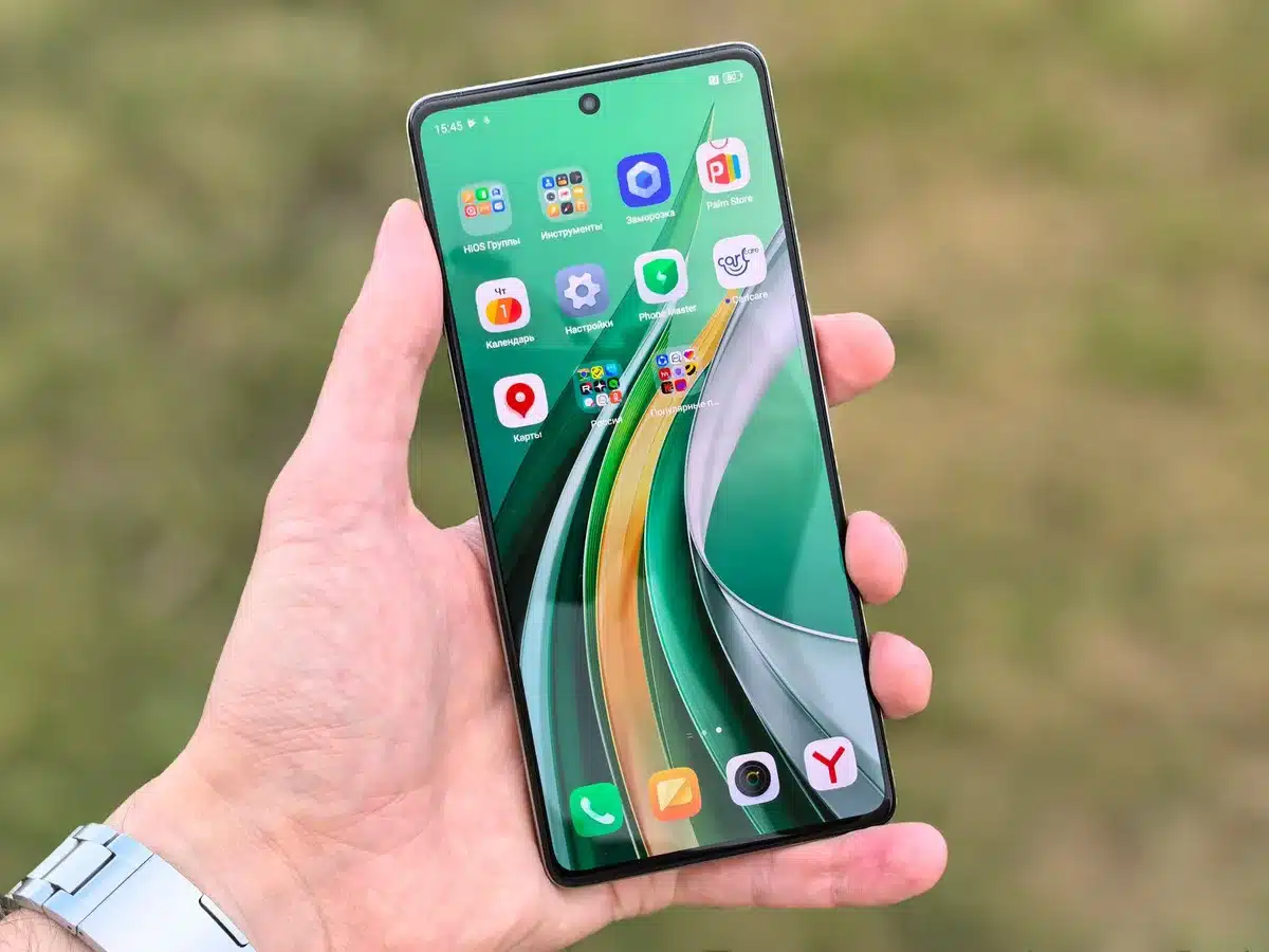 Mains tenant un smartphone moderne avec écran OLED brillant et module caméra visible