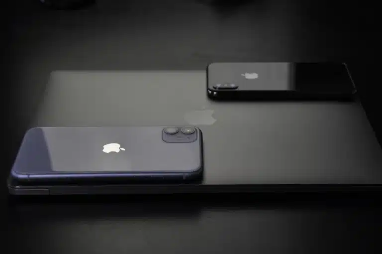 Smartphone and laptop showing software update notifications on a desk