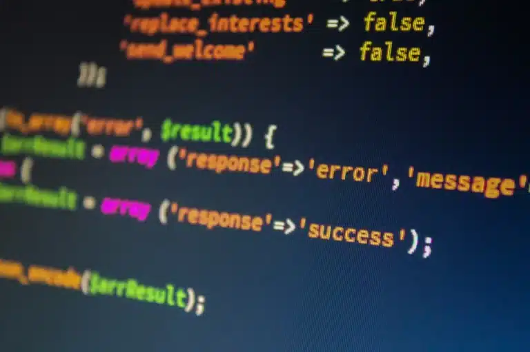 Närbild av programmeringskod på en mörk datorskärm med blått ljus