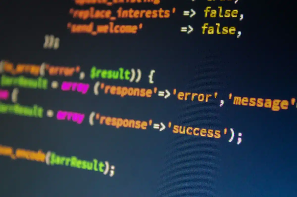 Närbild av programmeringskod på en mörk datorskärm med blått ljus