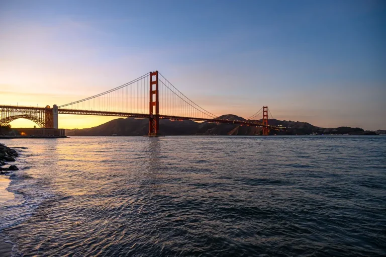Golden Gate Bridge at sunrise and sunset, showing the iconic arches with soft gradient lighting