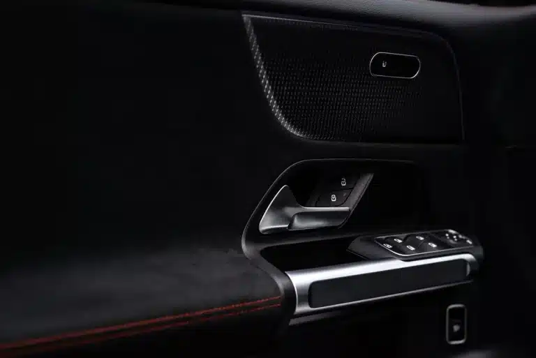 Smartphone displaying digital car key interface near a vehicle door