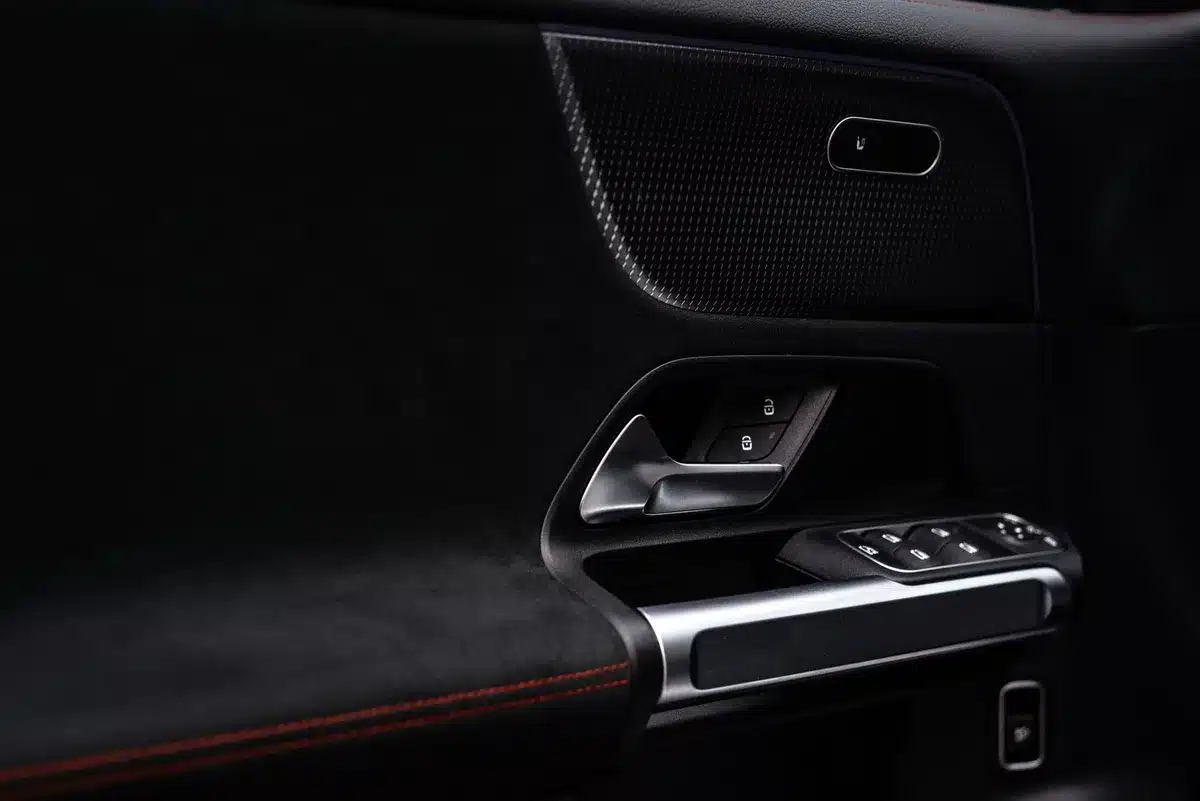 Smartphone displaying digital car key interface near a vehicle door