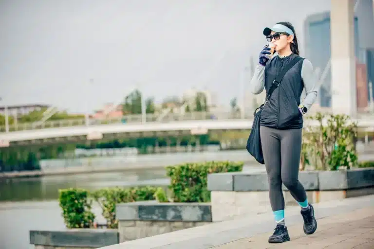 Person wearing a cooling vest device during hot weather, experiencing personal air conditioning relief