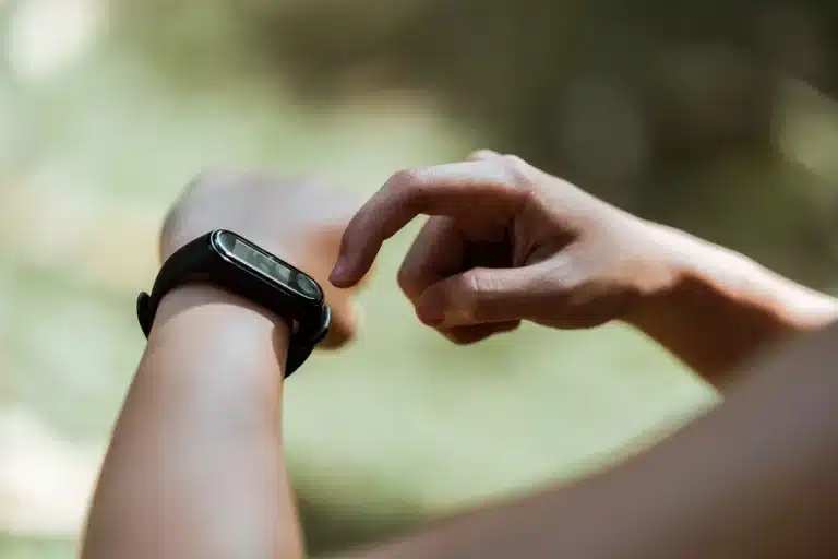 Sleek minimalist smartwatch displayed on neutral surface with visible rotating crown