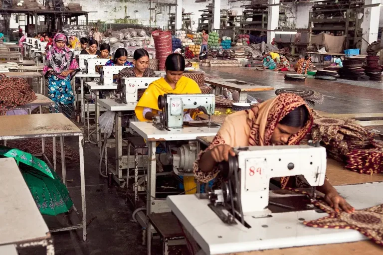 Technicians inspecting components on a factory assembly line with precision equipment