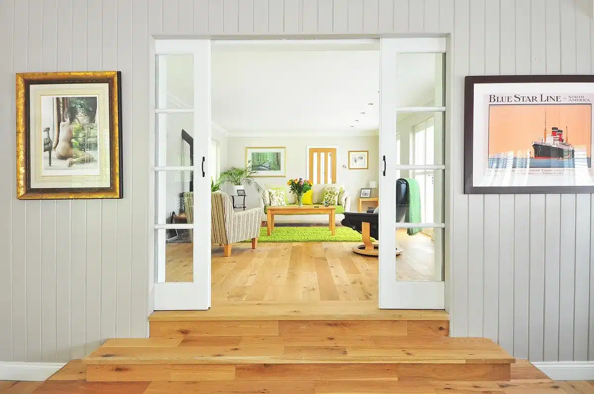 Dreame-style robot vacuum on wooden floor near baseboard, showing LiDAR dome