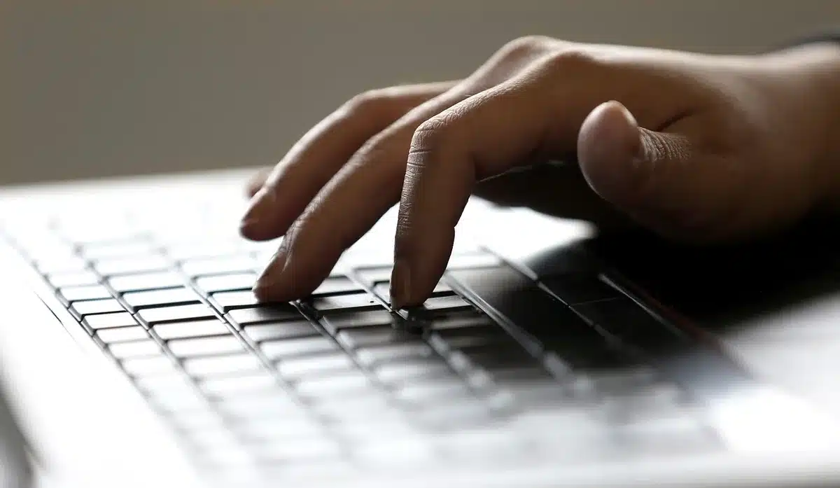 Clavier d'ordinateur portable avec mains en train de taper