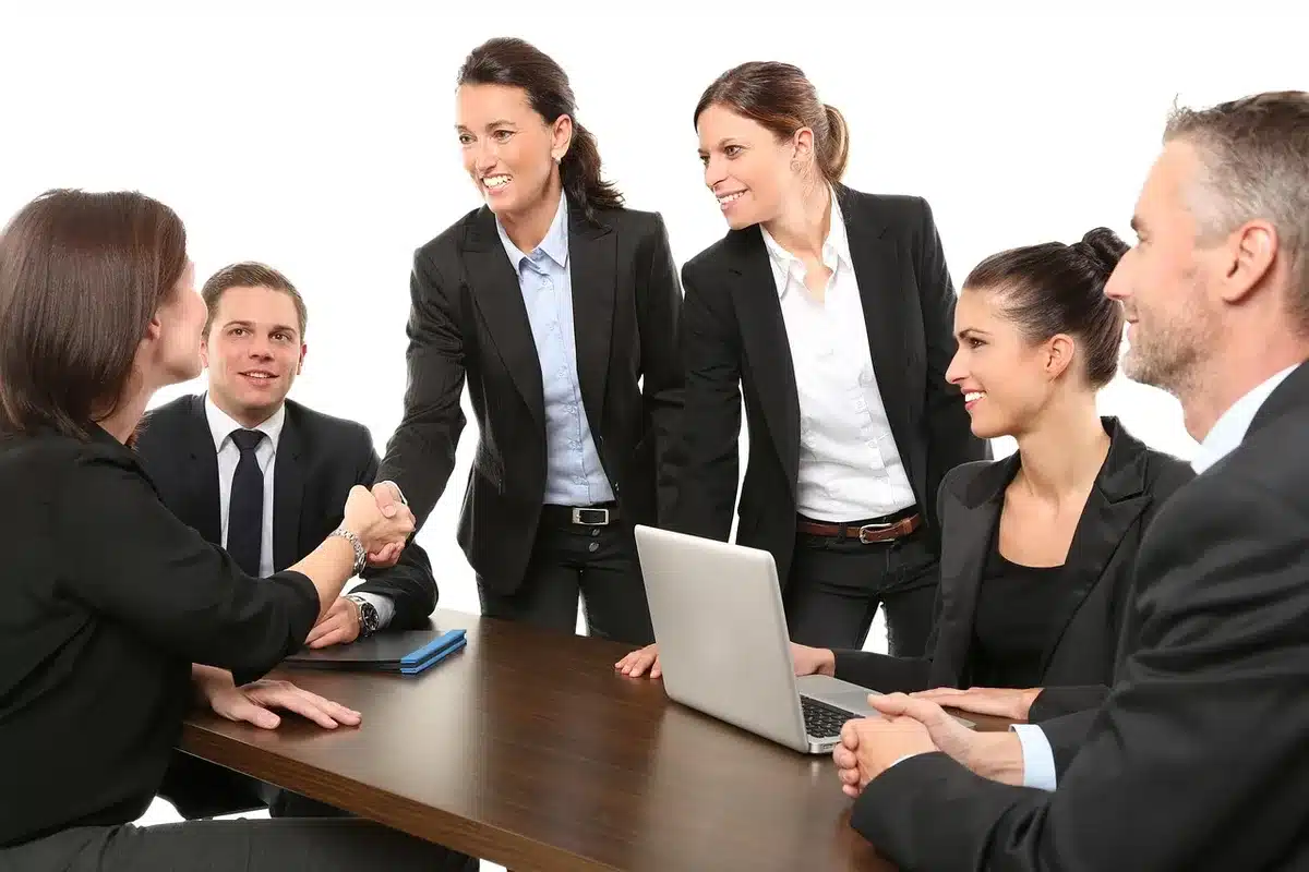 Colleagues around a table with a laptop and a small microphone recording a meeting
