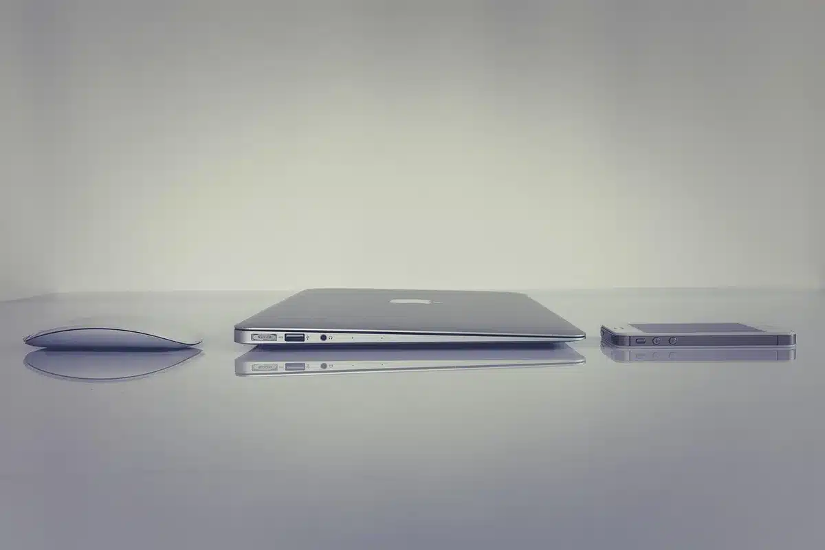 Smartphone on a sunlit table with a notebook and pen, hands tapping the screen