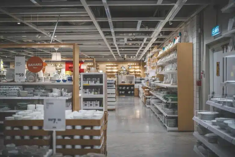 Hands reaching for headphones on a bright retail display table in daylight