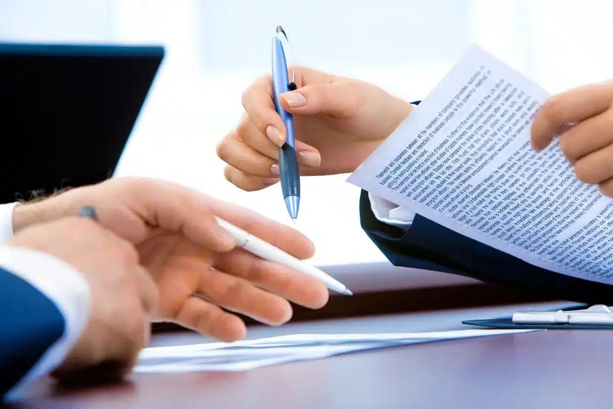 Sunlit office table with hands, laptop and documents about data policies
