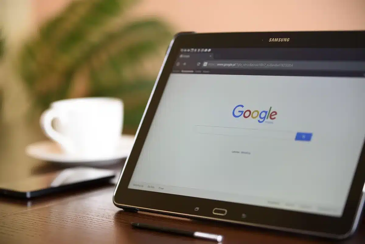 11-inch tablet on a desk with a smartphone showing a carrier logo and plan paperwork