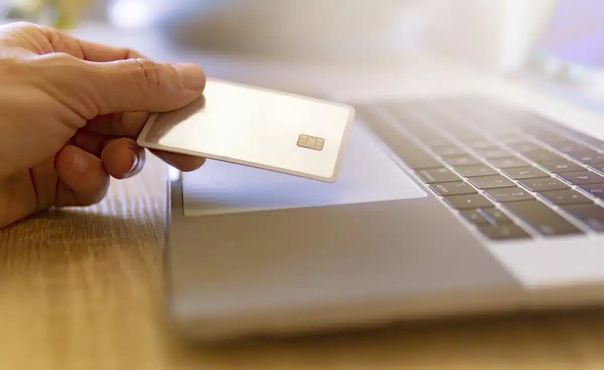 Persona completando compra online de un teléfono en una laptop