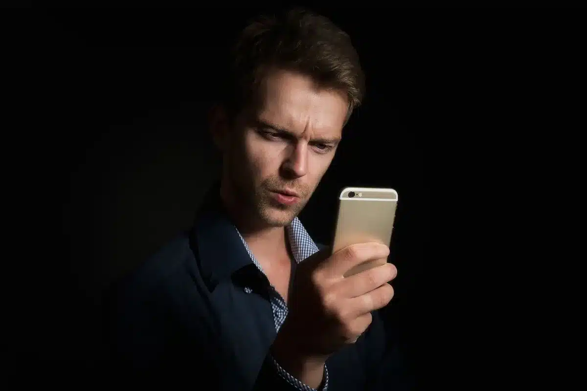 Reader holding a Kindle with a bright front light and crisp text visible