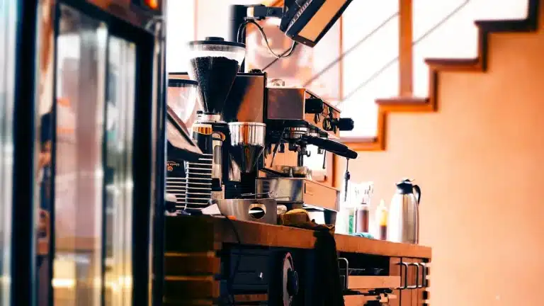 Compact espresso machine on a daylight kitchen counter with tamper and shot glass