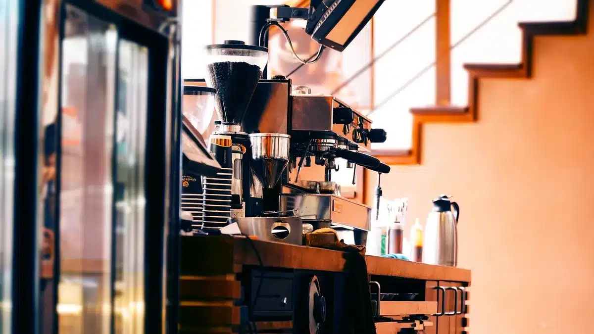 Compact espresso machine on a daylight kitchen counter with tamper and shot glass
