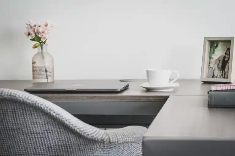 Smartphone and tablet on a sunlit living-room table with hands reaching for them
