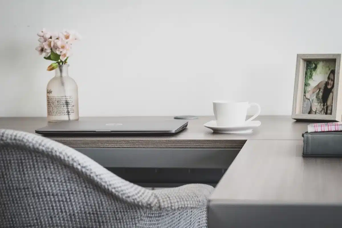 Smartphone and tablet on a sunlit living-room table with hands reaching for them