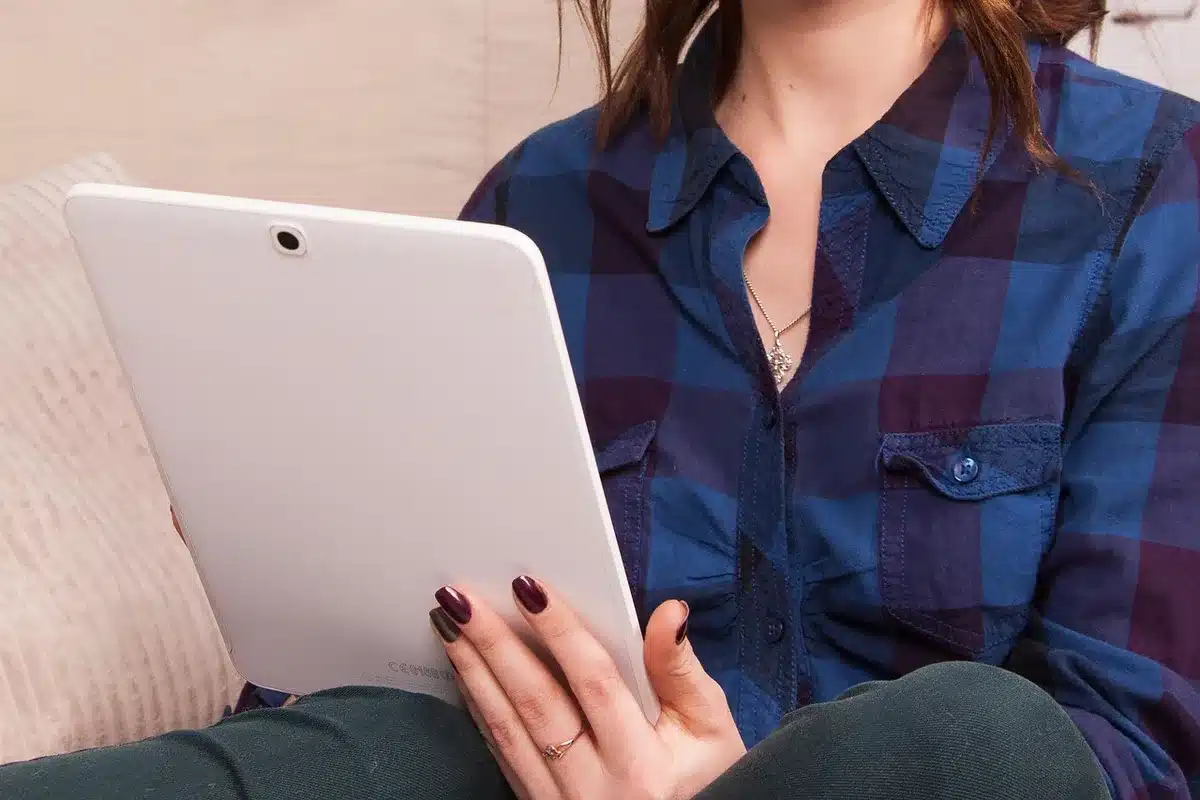 Person reading a matte-display tablet outdoors in bright sunlight