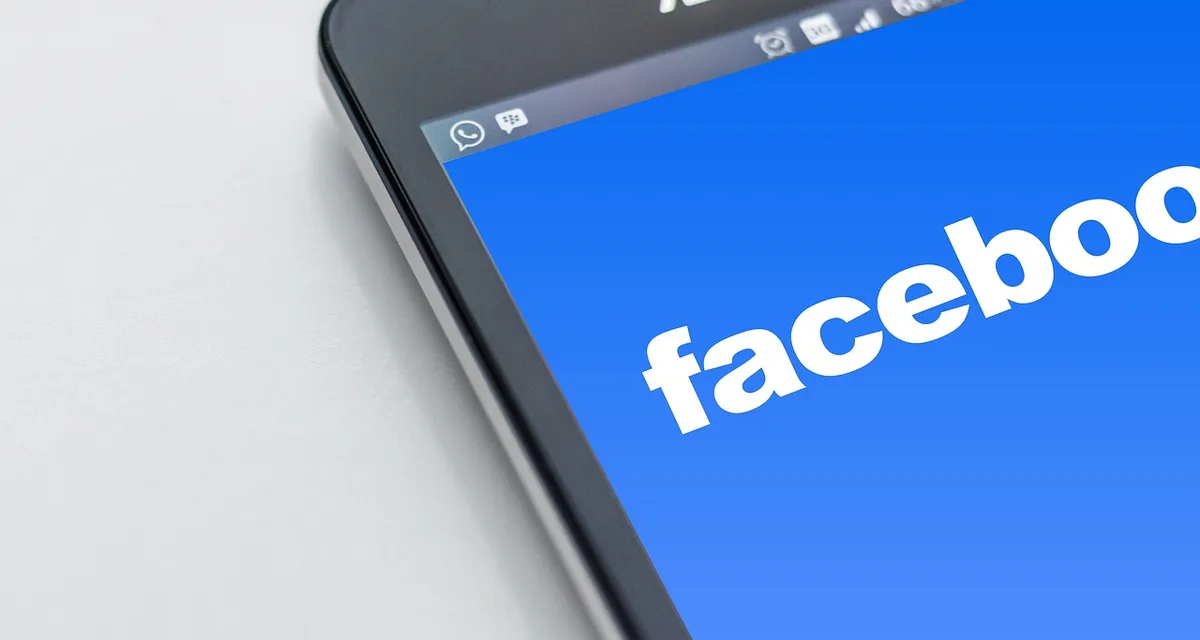 Persona usando redes sociales en un teléfono móvil para reportar una caída de servicio