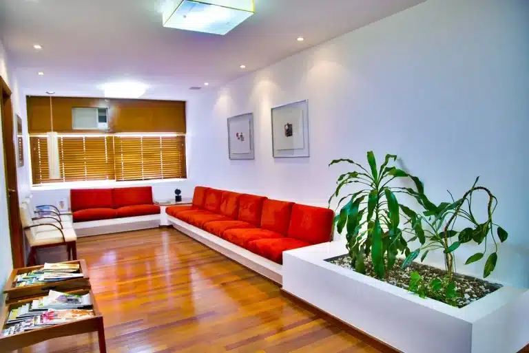 Large party speaker in a bright living room with daylight, hands adjusting controls
